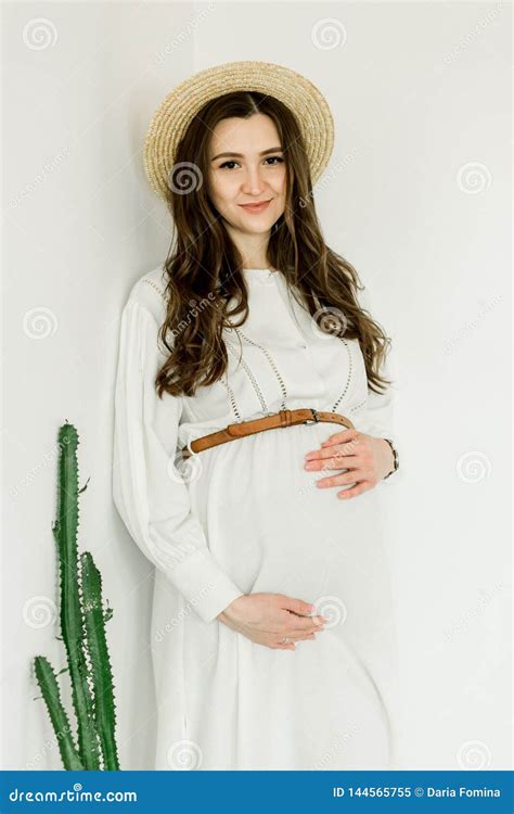 Young Pretty Pregnant Woman In Hat Standing Near Cactus Wall Stock