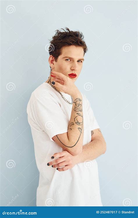 Un Joven Gay Está Parado En El Estudio Posando Para Una Cámara Labios De Lápiz Labial Rojo