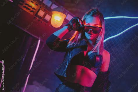 Young cyberpunk style girl in the neon lights concept. Stock Photo | Adobe Stock