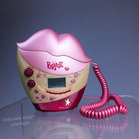 A Pink And Yellow Toy Phone Sitting On Top Of A Glass Table Next To A