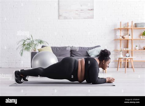 Side View Of African American Plus Size Woman In Sportswear Doing Plank