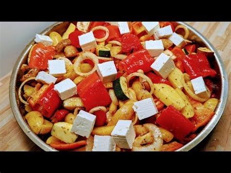 A Pan Filled With Pasta And Vegetables On Top Of A Wooden Table