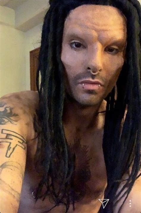 A Man With Long Dreadlocks And No Shirt On Is Looking At The Camera