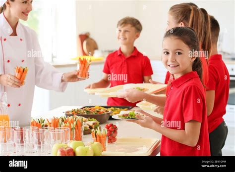 Pupils Receiving Lunch In School Canteen Stock Photo Alamy