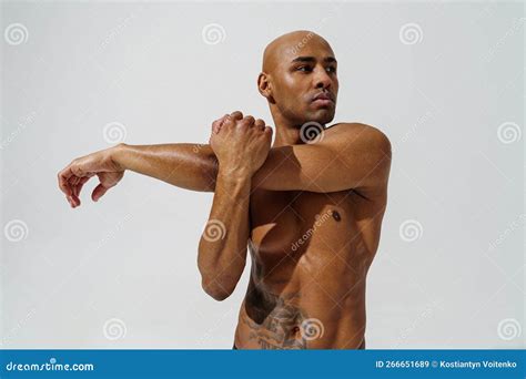 Athletic Man With Naked Torso Is Stretching His Hands Before Workout On Studio Background Stock