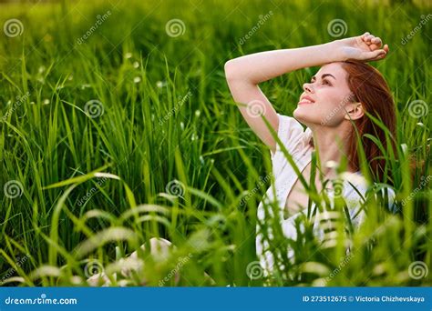 Cute Woman With Red Hair Sits In Tall Green Grass With Her Hand On Her Head Stock Image Image