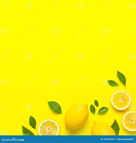 Creative Background With Fresh Lemons And Green Leaves On Bright Yellow