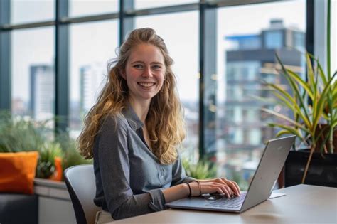Premium Photo A Woman With Long Blonde Hair Sits At A Desk With A Laptop