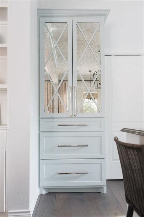 A Custom Light Blue China Cabinet Is Fitted With Smoked Mirror Doors