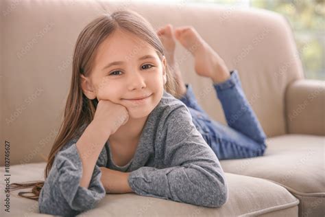 Cute Little Girl Lying On Sofa At Home Stock Photo Adobe Stock