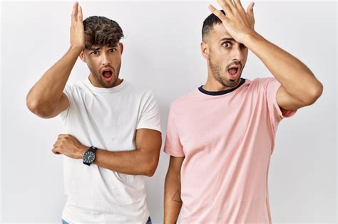Joven Pareja Gay De Pie Sobre Un Fondo Aislado Sorprendido Con La Mano En La Cabeza Por Error