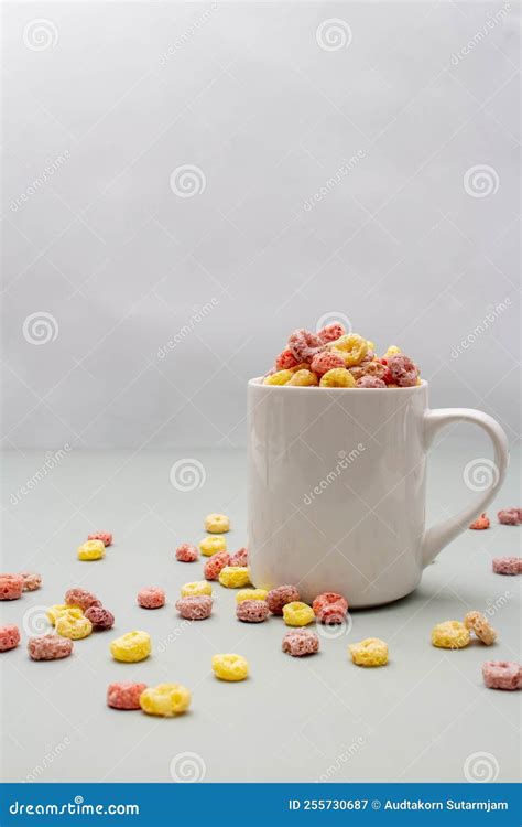 Breakfast Cereal Concept Colorful Ring Cereals In Coffee Cup And Falling On Grey Background