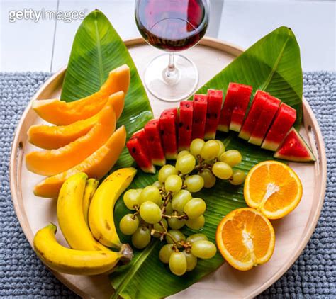 Red Wine Glass With A Tray Of Different Fruits For A Picnic 이미지