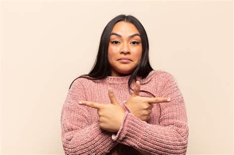 Joven Latina Que Parece Perpleja Y Confundida Insegura Y Apuntando En Direcciones Opuestas Con