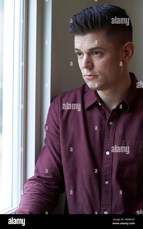 Sad Man Suffering From Depression Looking Out Of Window Stock Photo - Alamy