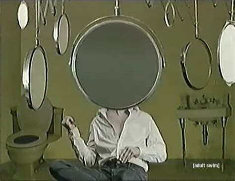 A Man Sitting On The Floor With A Giant Pan Over His Head In Front Of Him