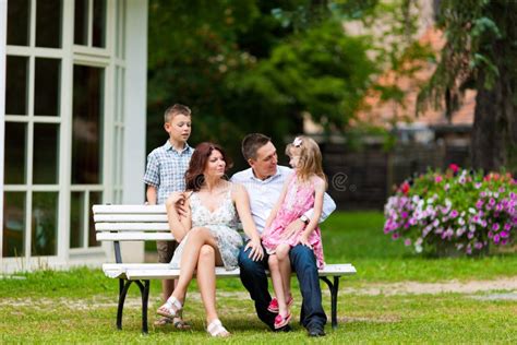 Famille S Asseyant Devant Leur Maison Image Stock Image Du Quatre