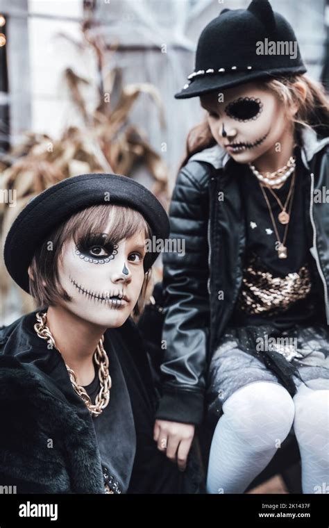 Beautiful scary little girl celebrating halloween. Terrifying black, white half-face makeup ...