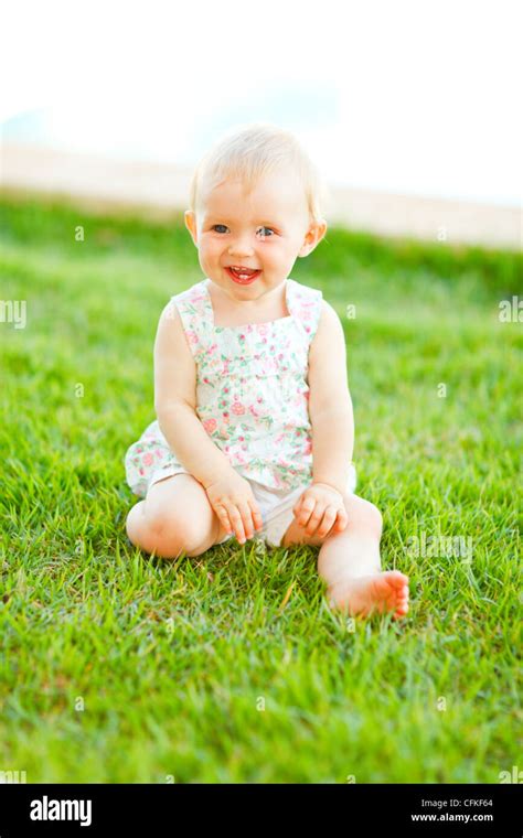 happy baby sitting  grass stock photo alamy