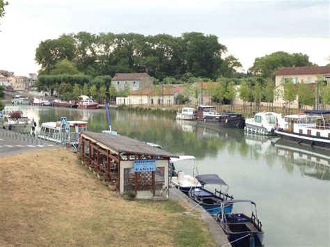 Several Boats Are Docked On The Water Near Some Buildings And Trees