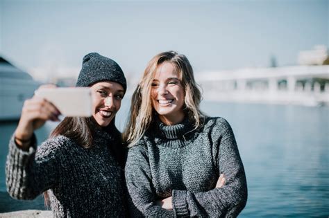 Deux Femmes Prenant Selfie Avec De L Eau En Arri Re Plan Photo Gratuite