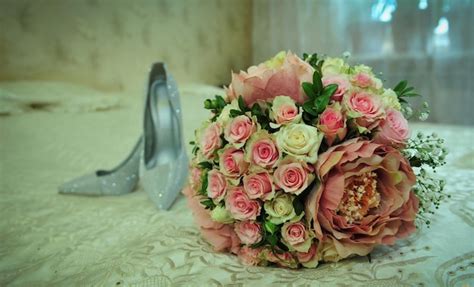 Un Ramo De Rosas Se Sienta En Una Mesa Al Lado De Una Caja Plateada