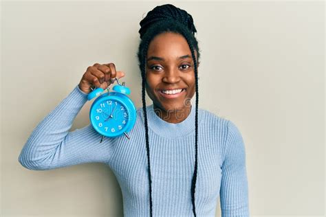 Mujer Afroamericana Con El Pelo Trenzado Sosteniendo Un Reloj