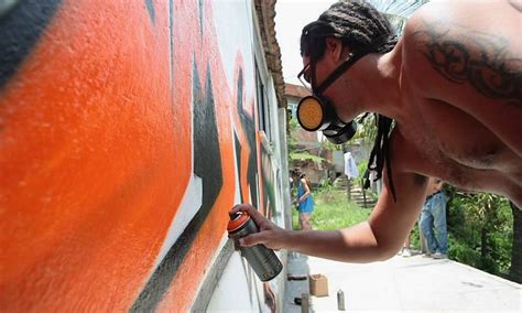 Alunos de curso de grafite pintam casas no alto do Complexo do Alemão