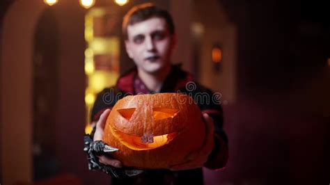 Young Man In A Halloween Costume Of Count Dracula Raises A Carved Pumpkin Stock Footage Video