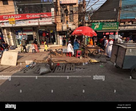 A Dirty Sidewalk With Street Food Vendors On The Street Of Dhaka City