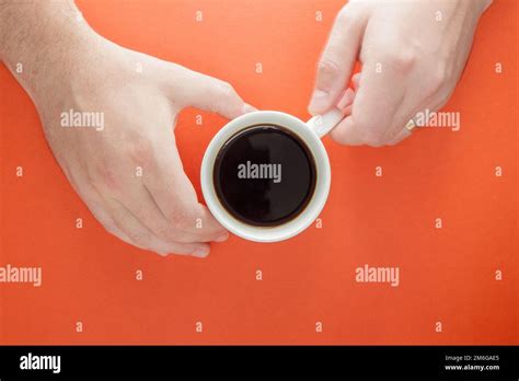 Male Hands Hold A Cup Of Hot Americano Coffee On A Bright Plain