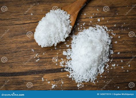 Salt In Wooden Spoon And Heap Of White Salt On Wood Background Stock