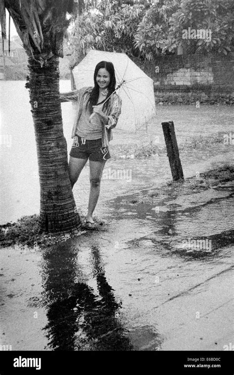 Young Woman With Umbrella Enjoying Heavy Rain During A Monsoon Downpour