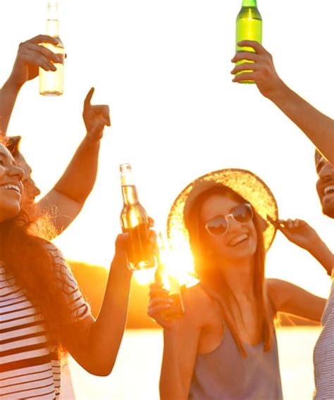 Three Women Are Toasting With Beer In Front Of The Sun At An Outdoor Event