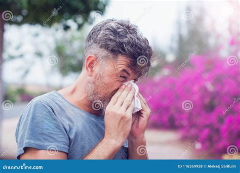 Man Sneezing in a Tissue Outdoors. Pollen Allergy, Springtime Stock ...