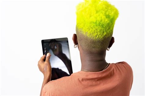 Un hombre negro gay maquillándose concepto lgbti poniéndose sombra de ojos Foto Premium