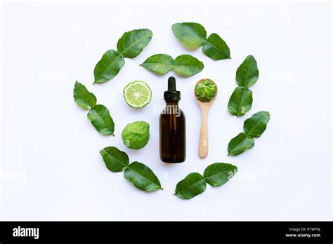 Bottle Of Essential Oil And Fresh Kaffir Lime Or Bergamot Fruit With Leaves Isolated On White