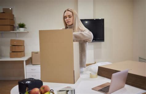 Kaukasisches Mädchen klebt Kisten für den Umzug in eine neue Wohnung