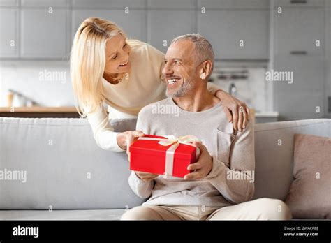 Loving Mature Woman Giving Present Her Surprised Husband Stock Photo Alamy