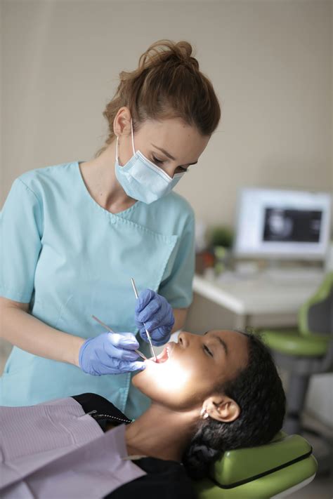 Young female dentist treating teeth of patient in modern clinic · Free ... 