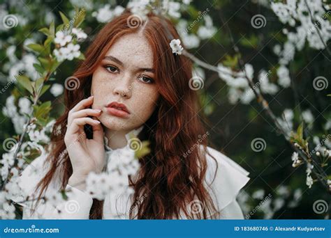 Fille Redhaired Avec Des Taches De Rousseur Dans Les Fleurs De