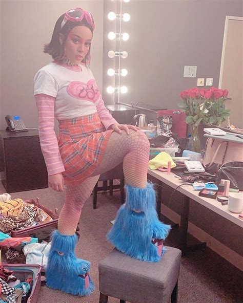 a woman sitting on top of a stool in front of a mirror wearing blue ...