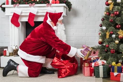 Premium Photo Santa Putting Presents Under Christmas Tree Presents