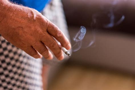 Mão cortada de homem segurando um cigarro Foto Premium