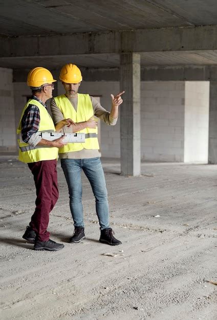 Premium Photo Two Caucasian Engineers Discussing On Construction Site