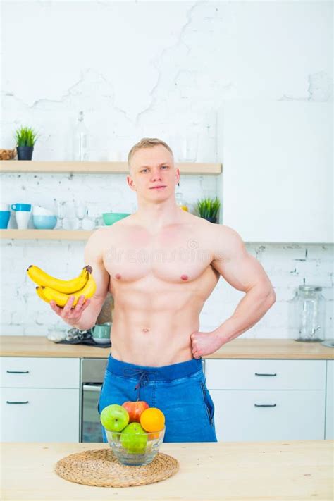 Muscular Man With A Naked Torso In The Kitchen With Fruit Concept Of Healthy Eating Athletic