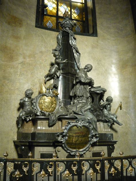 An Ornate Clock In Front Of A Stained Glass Window With Gold Accents