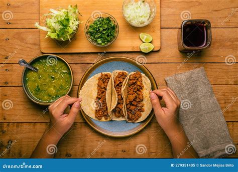 Woman S Hand Holding A Taco Of Marinated Meat Plate With Tacos Sauce