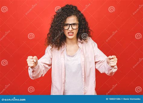 Disappointed Caucasian Brunette Woman Looking Agressive Isolated On Red Background In Studio