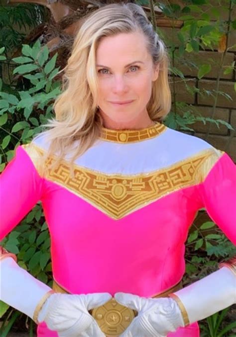 A Woman In A Pink And Gold Costume Posing For A Photo With Her Hands On